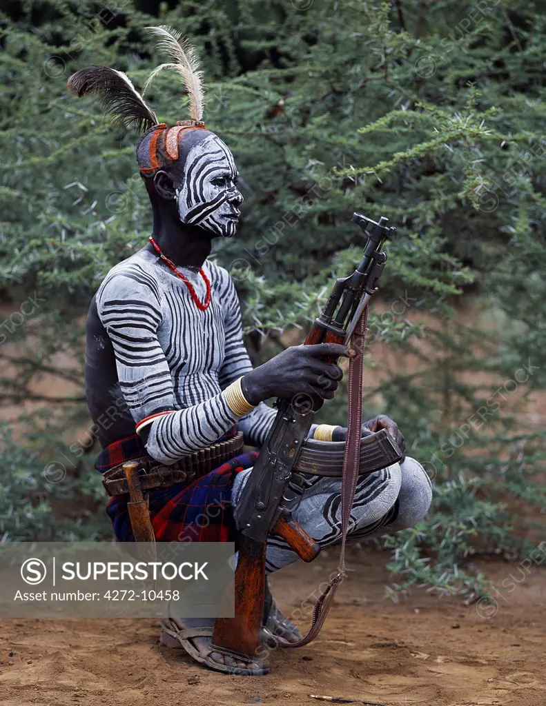 An elder of the Karo tribe, a small Omotic tribe related to the Hamar, who live along the banks of the Omo River in southwestern Ethiopia.  The Karo are renowned for their elaborate body painting using white chalk, crushed rock and other natural pigments.  This man also has a clay hairdo typical of tribal elders.  Like most adult males he carries a rifle.