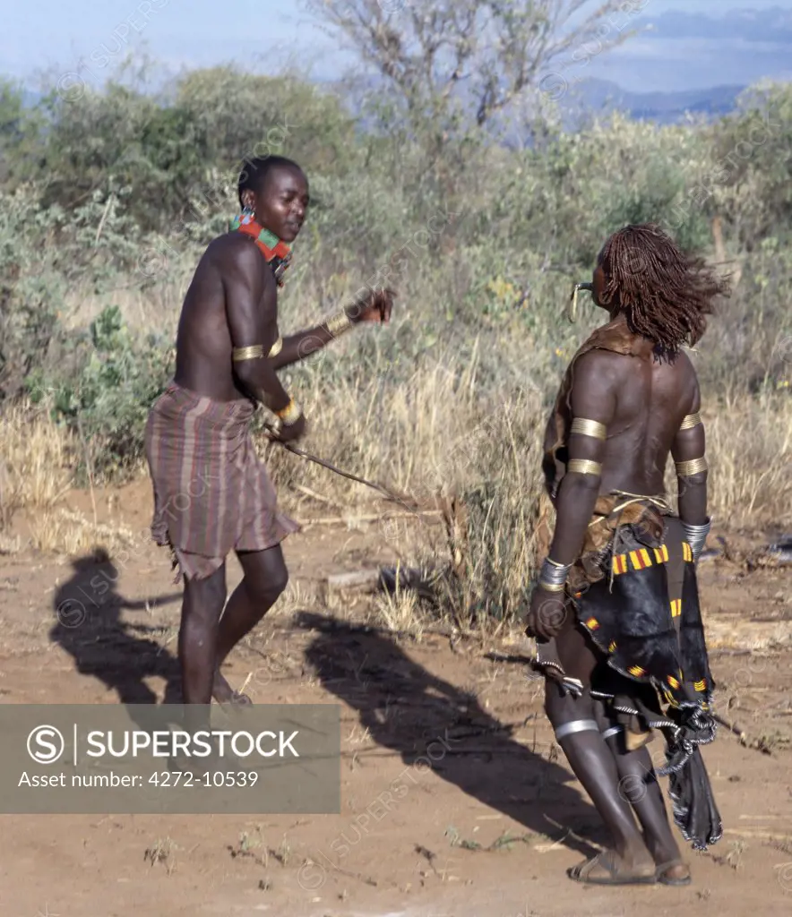 A Hamar woman being whipped. During a Hamar Jumping of the Bull ceremony, female friends and relatives of the initiate are willingly whipped with pliable sticks to show their solidarity and love for him.  They do not flinch or show any sign of pain.
