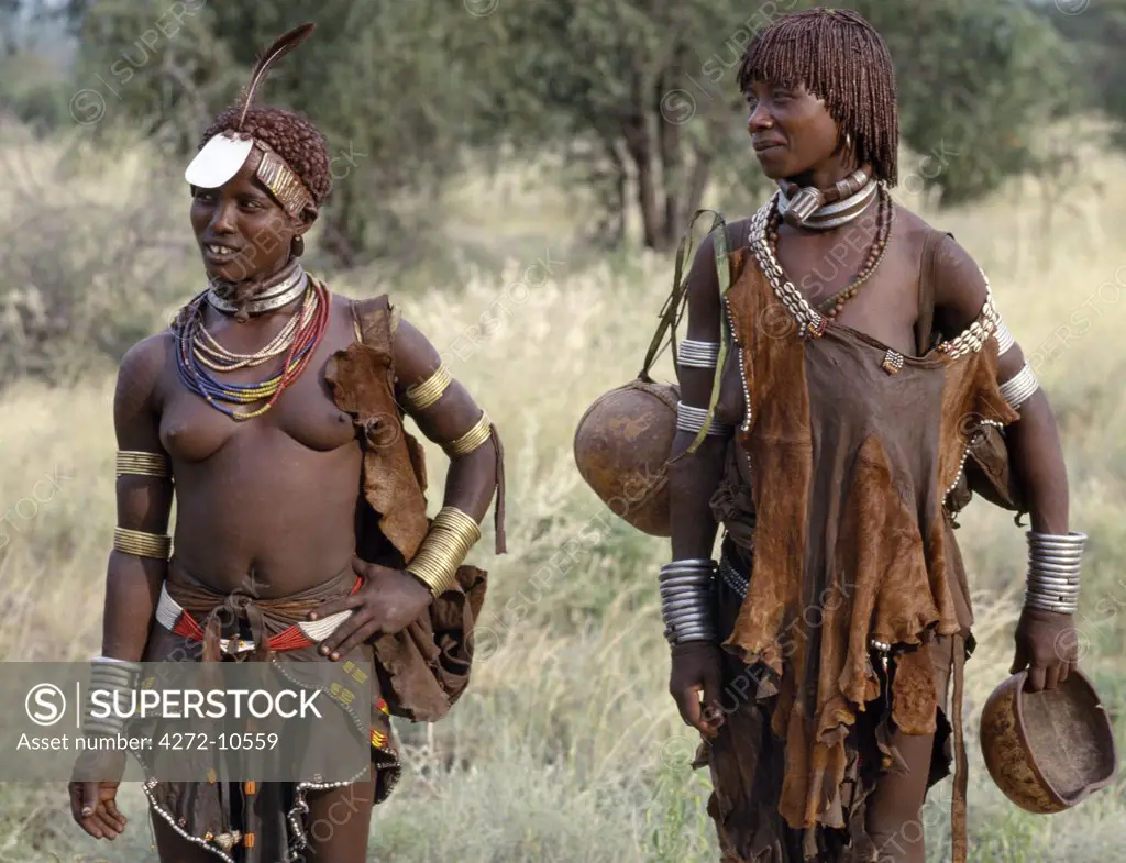 Hamar women of Southwest Ethiopia.  The phallic protrusion on the necklace of the  woman on the right denotes that she is her husbands first wife. The Hamar are semi nomadic pastoralists whose richly ochred women have striking styles of traditional dress.