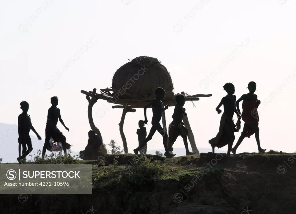 In the late afternoon, a group of Dassanech children wave to passing visitors along a bank of the Omo River in Southwest Ethiopia. The Dassanech speak a language of Eastern Cushitic origin. They live in the Omo Delta and they practice animal husbandry and fishing as well as agriculture.
