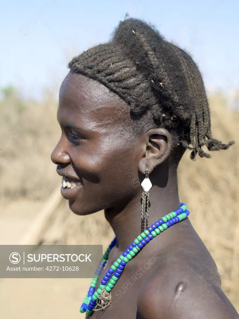 A finely braided hairstyle of a young Dassanech man. The Omo Delta of southwest Ethiopia is one of the least accessible and least developed parts of East Africa.