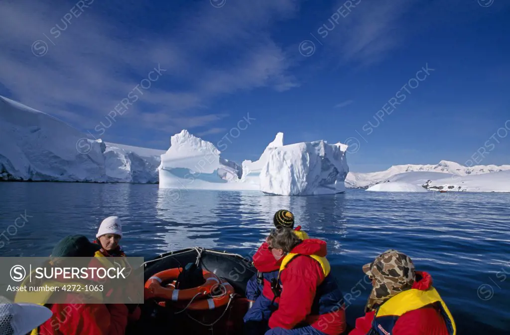 Antarctica, Melchior Islands, Dallman Bay. Tourists Zodiac cruising near grounded iceberg
