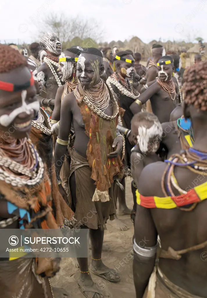 Karo villagers assemble for a dance. The Karo excel in body art.  Before dances and ceremonial occasions, they decorate themselves elaborately using local white chalk, pulverised rock and other natural pigments.   The Karo are a small tribe living in three main villages along the lower reaches of the Omo River in southwest Ethiopia.