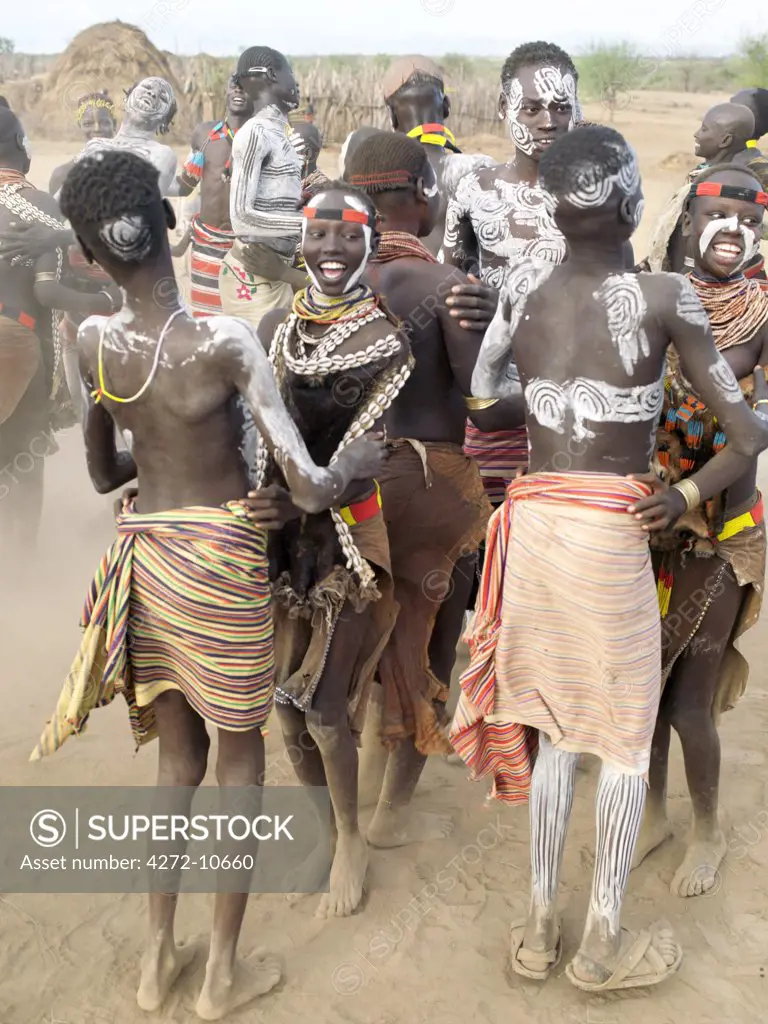 Karo men and girls enjoy a dance. The Karo excel in body art.  Before dances and ceremonial occasions, they decorate themselves elaborately using local white chalk, pulverised rock and other natural pigments. The Karo are a small tribe living in three main villages along the lower reaches of the Omo River in southwest Ethiopia.