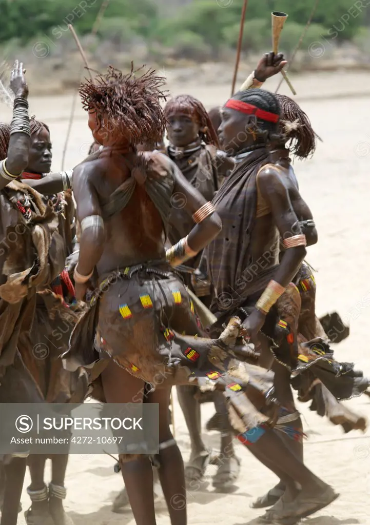Hamar women dance during a Jumping of the Bull ceremony. The Hamar are semi nomadic pastoralists of Southwest Ethiopia whose women wear striking traditional dress and style their red ochred hair mop fashion.