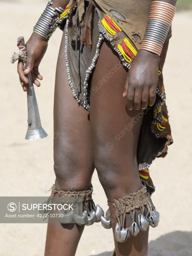 Close up of a young Hamar womans attire during a Jumping of the Bull ceremony.  She holds a Hamar tin trumpet in her right hand, which are only blown by women.The semi nomadic Hamar of Southwest Ethiopia embrace an age grade system that includes several rites of passage for young men.