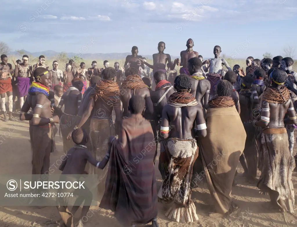 In the late afternoon, Nyagatom villagers enjoy singing and dancing.  As groups of men take centre stage to jump high in the air, women and girls sing, clap to a rhythm, and move slowly towards the men.  Children enjoy the excitement in the background. The Nyagatom are one of the largest tribes and arguably the most warlike people living along the Omo River in Southwest Ethiopia.