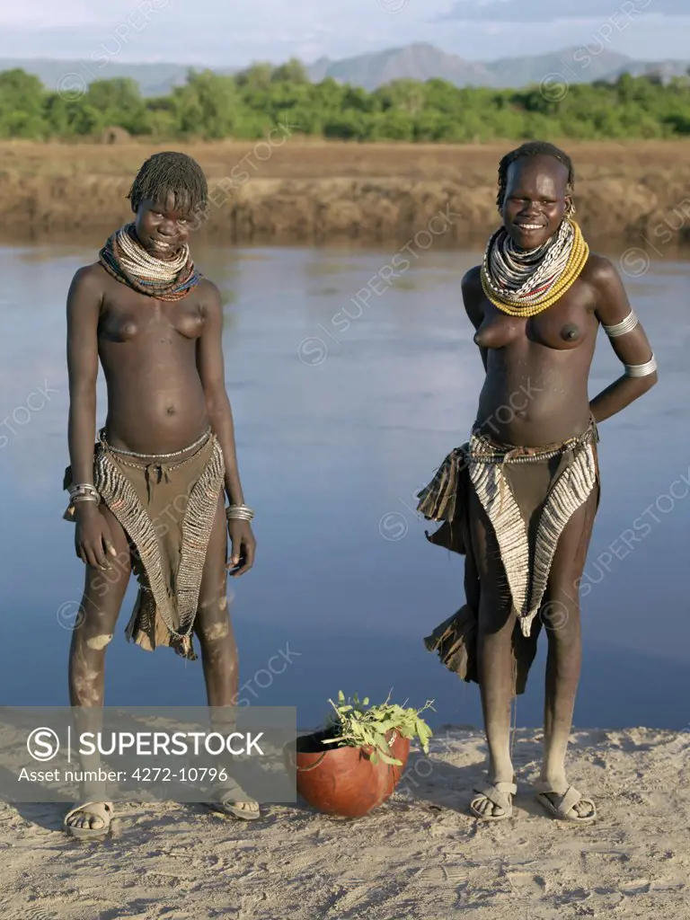 The contrasting leather aprons or skirts of two Nyagatom girls.  The skirt on the left is richly decorated with metal and copper beads, the one on the right is embellished with thousands of small white discs or beads, handmade from ostrich shells.The Nyagatom are one of the largest tribes and arguably the most warlike people living along the Omo River in Southwest Ethiopia.
