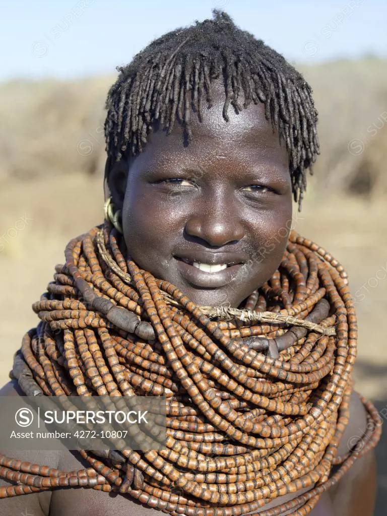 A Nyagatom woman wears numerous strands of beads made from wood.The Nyagatom are one of the largest tribes and arguably the most warlike people living along the Omo River in Southwest Ethiopia.