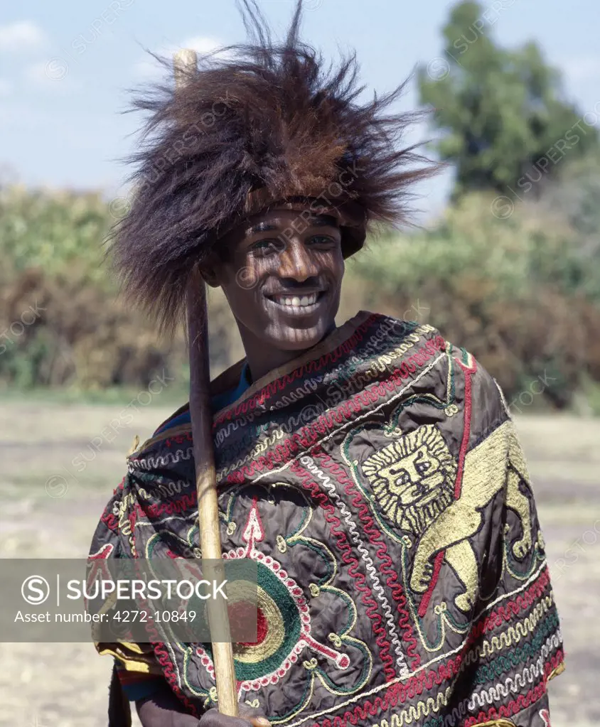 An Ethiopian man wears a headdress made from the skin of a gelada, a unique baboon like primate that lives at high altitudes in northern Ethiopia, and a cloak embroidered with Ethiopia's imperial lion.
