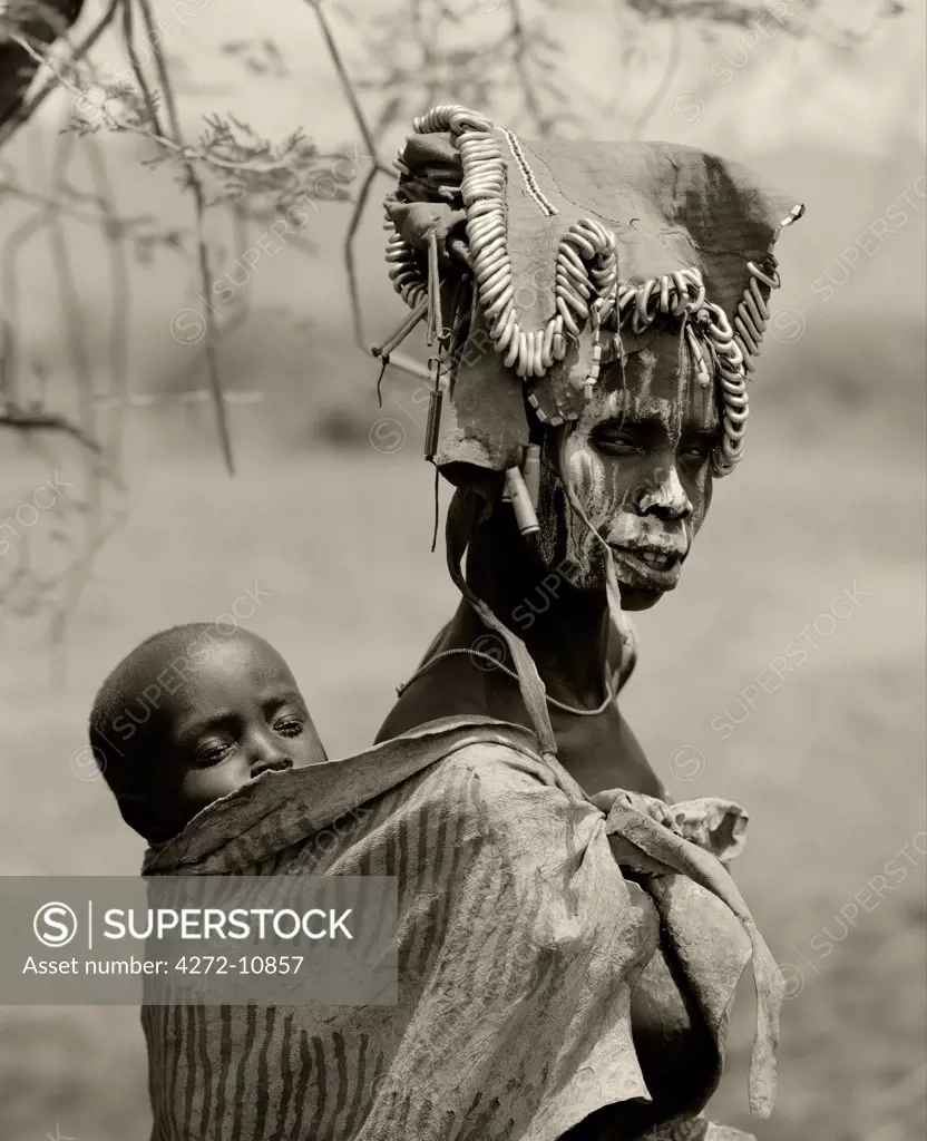 Ethippia, Omo Delta.  A woman from the Mursi tribe with her child on her back.