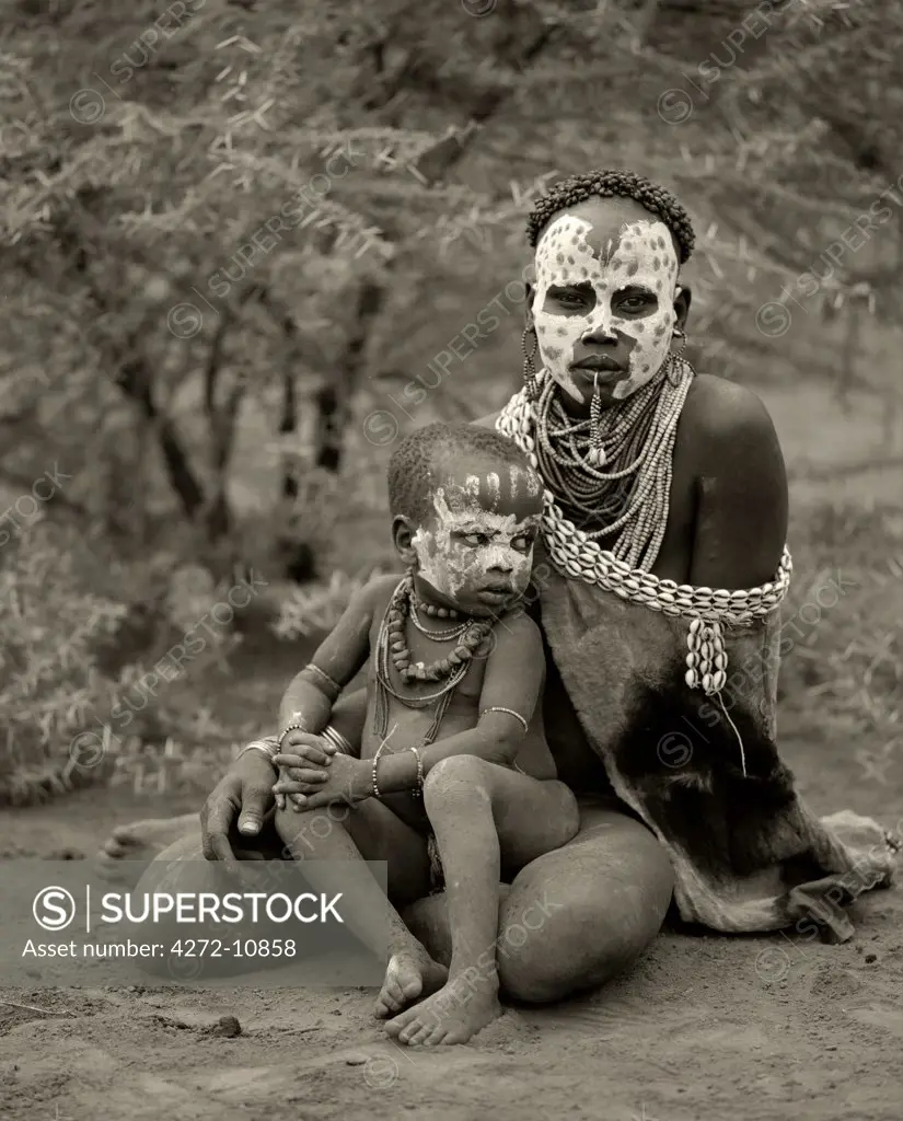Ethiopia, Omo Delta.  A woman from the Karo tribe, famous for their face painting, with her child.