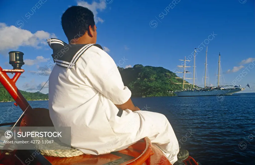 French Polynesia, Society Islands, Leeward Islands, Huahine Island (aka Mata'irea). A seaman returns to the Star Flyer, a barquentine opearted by Star Clippers, on a shuttle boat.
