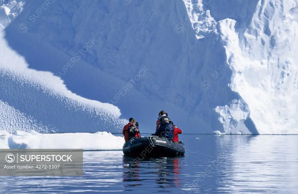 Antarctica, Errera Channel. Tourists Zodiac cruising among icebergs near Cuverville Island.