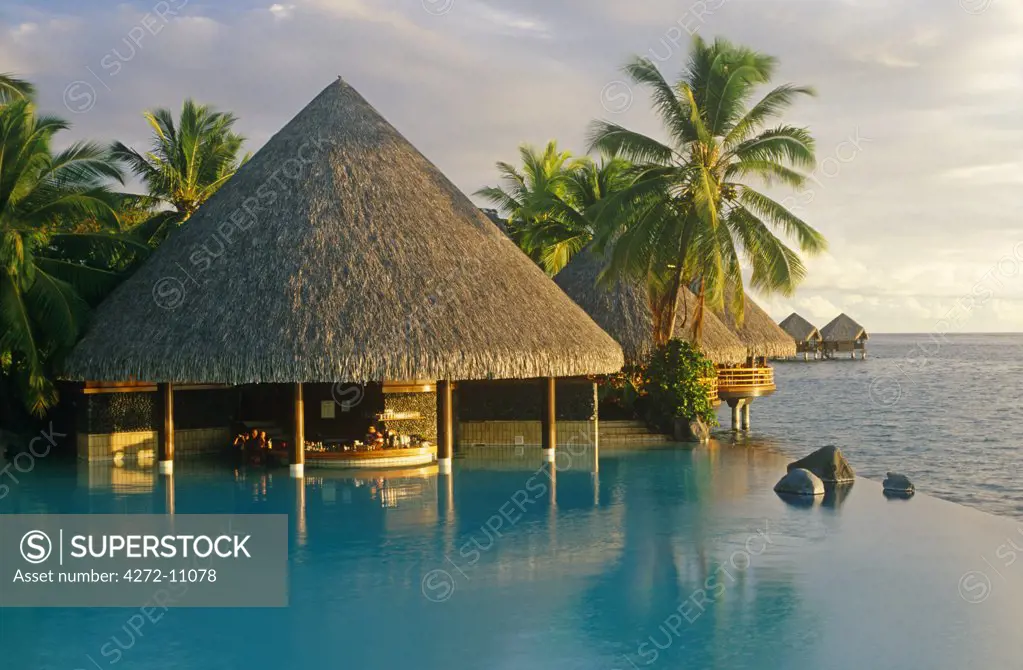 French Polynesia, Society Islands, Leeward Islands, Tahiti, Pape'ete. The pool-bar of the Intercontinental Hotel looks out over the sea and some of its over-water cottages.