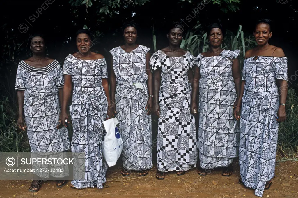 Ghana, Ashanti region, Edwinase. Women wearing adinkra fabric.