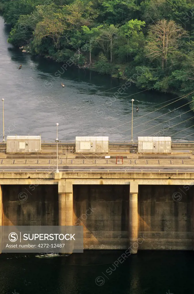 Ghana, Volta Region, Akosombo. View of the Akosombo Dam with canoes and power cables.