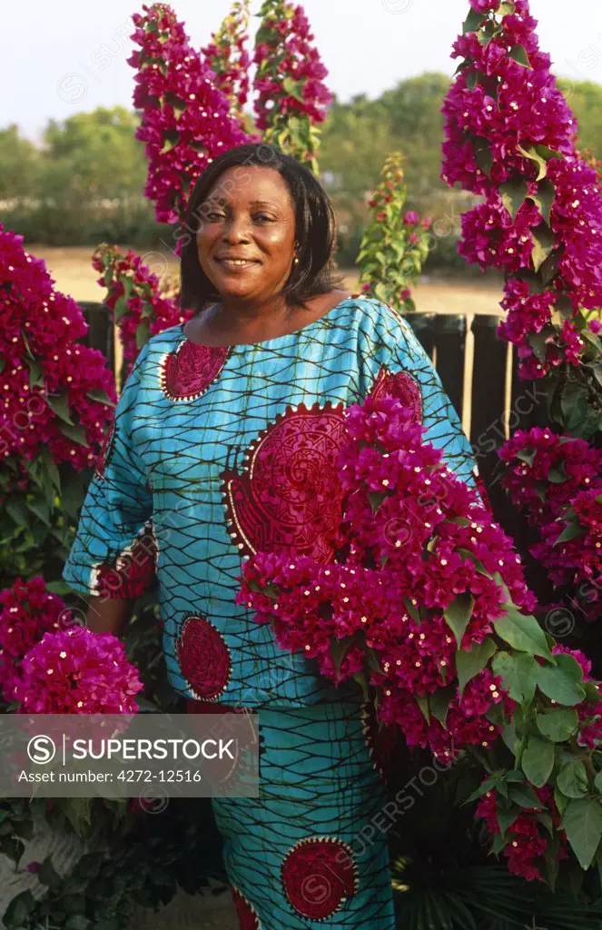 Ghana, Volta region, Ada. Woman with flowers near Ada, Volta.