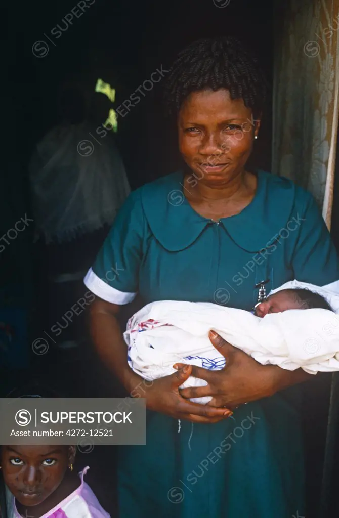 Ghana, Volta Region, Hohoe. Midwife nurse with a baby.