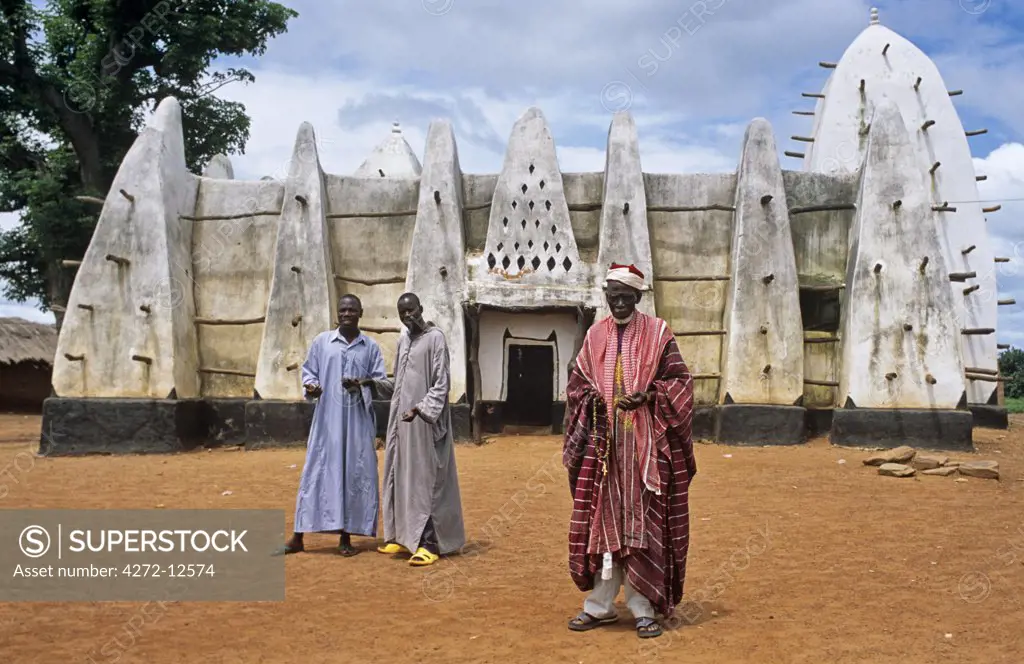 Ghana, Northern Region, Larabanga. The Imam and two young muslims stand outside the thirteenth century mosque at Larabanga, near Mole National park.