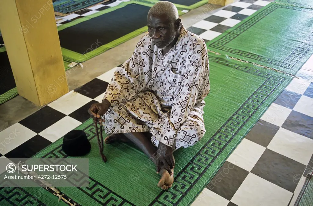 Ghana, Northern region, Tamale. A Muslim prays at a Mosque in Tamale during Ramadan.