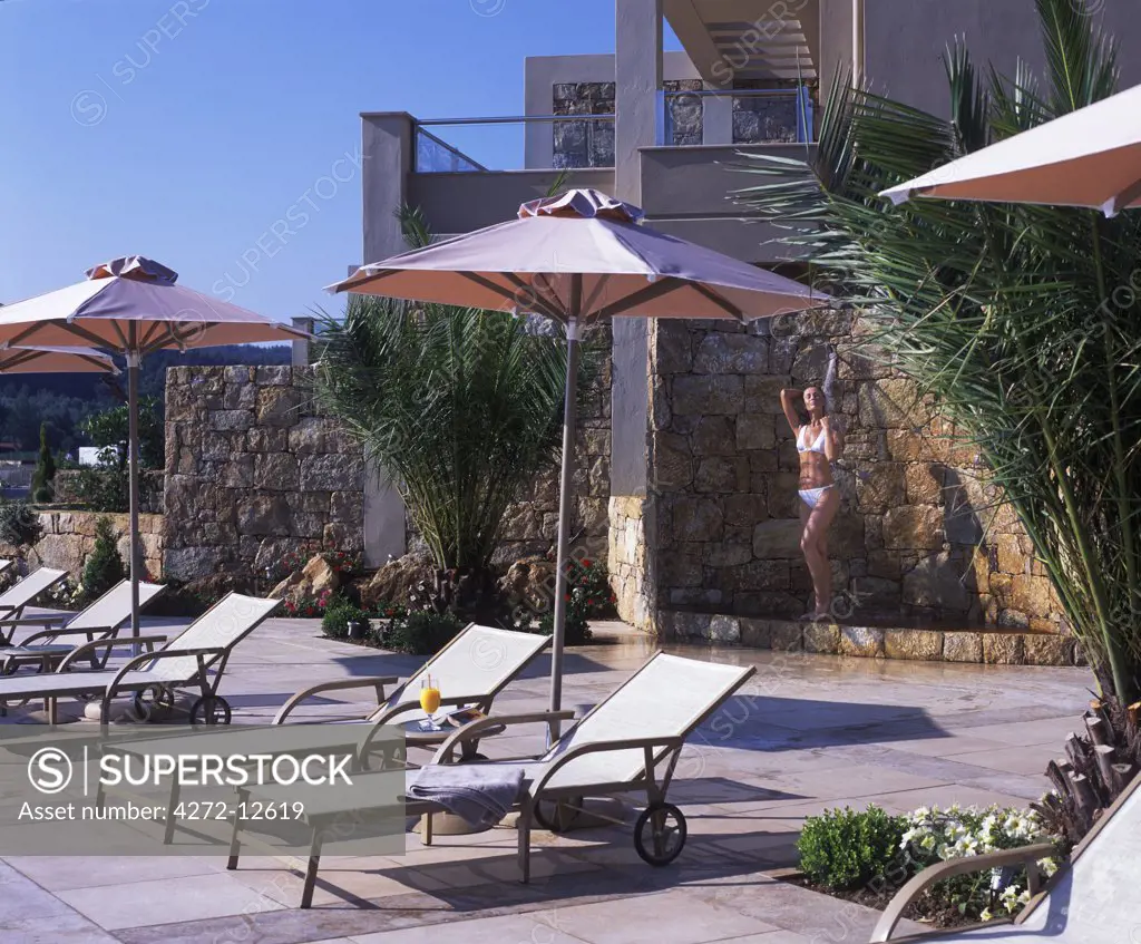 Sun loungers and open air shower at the Asterias Suites' swimming pool