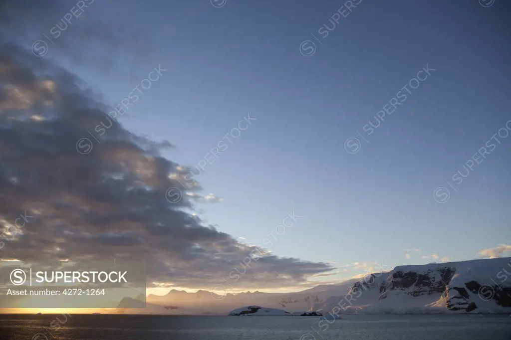 Antarctica, Peninsula.   Sunset over the Antarctic Peninsula with the clouds of a cold front being occluded by an area of high pressure.