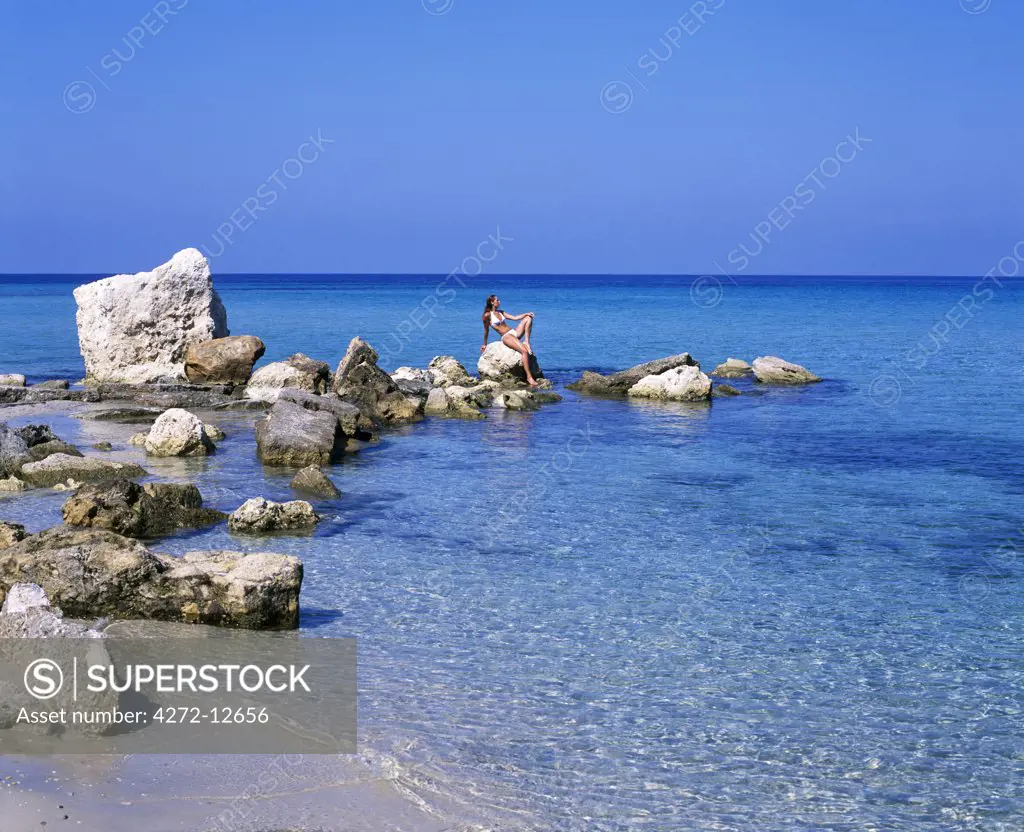 Girl sun-bathing on rocks at Boussolos Beach