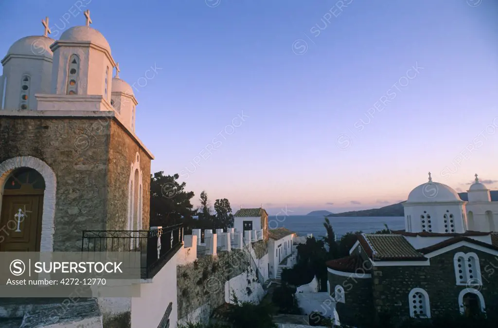 Greece, Peloponnese, Messinia, Koroni. Sunset tinges the whitewashed chapel domes of Timiou Prodhromou nunnery which stands alongside the bastions of Koroni's medieval citadel.