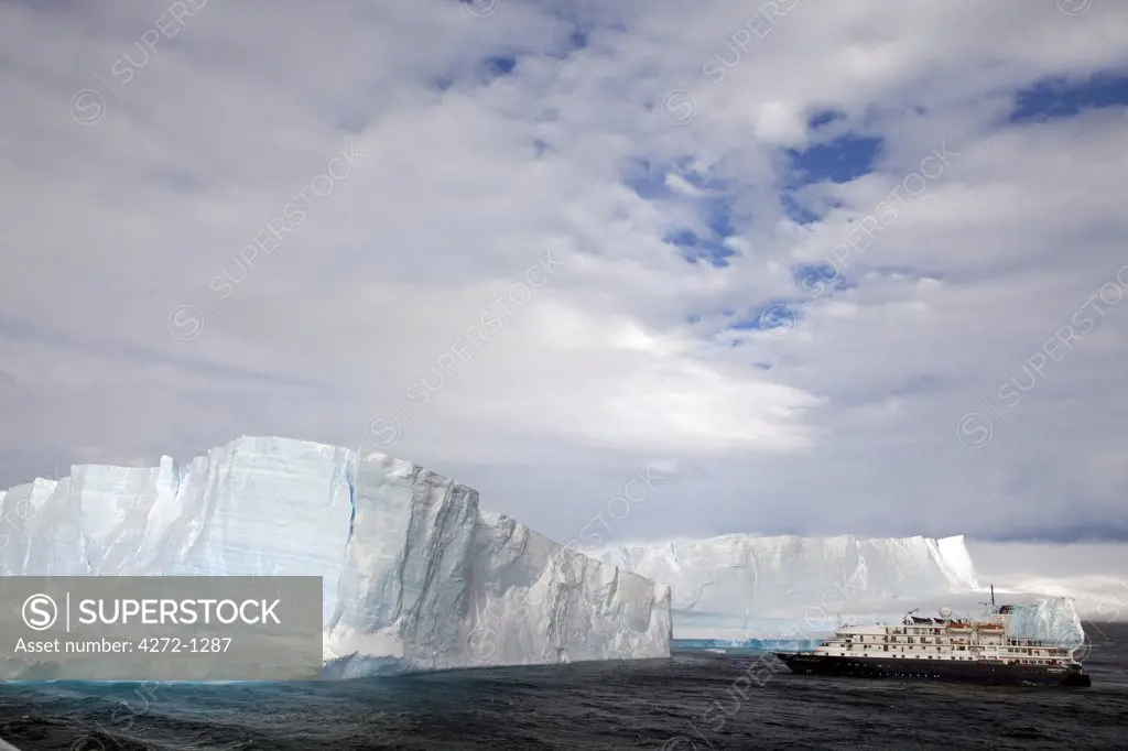 Antarctica, Antarctic Sound and Hope Bay,  expedition ship the Corinthian III is dwarfed by the massive bulk of tabular icebergs littering Antartic Sound