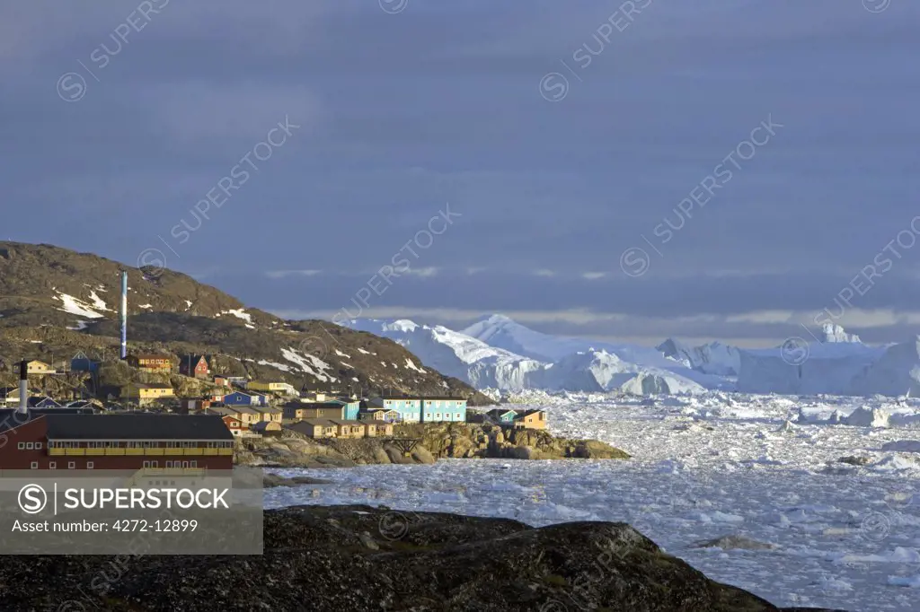 Greenland, Ilulissat, UNESCO World Heritage Site Icefjord.   The entrance to the port area of the town showing scattered bergy bits and large tabular bergs in the background.