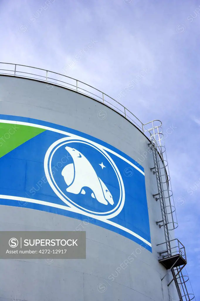 Greenland, Ilulissat. On the side of an oil bunkering tank at the entrance to the main port area, the North Star and Polar Bear make up the local supply companies logo.