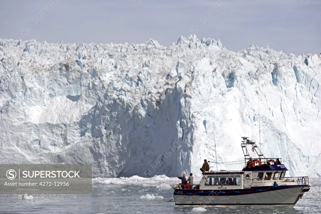 Greenland, Eqi Glacier.   The high level of activity at the Eqi Glacier attracts sight-seeing boats and tourists keen to watch pieces of the ice face calving into the bay in front of the glacial snout.