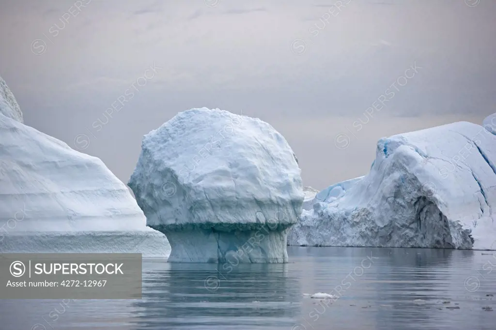 Greenland, Ilulissat, UNESCO World Heritage Site Icefjord.  A cruise around the icefjord in the late evening taking advantage of the midnight sun reveals some fascinating ice sculptures and massive icebergs.