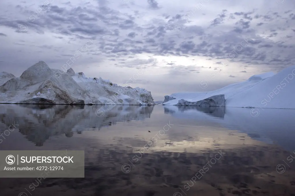 Greenland, Ilulissat, UNESCO World Heritage Site Icefjord.  A cruise around the icefjord in the late evening, taking advantage of the midnight sun reveals some fascinating ice sculptures and massive icebergs.