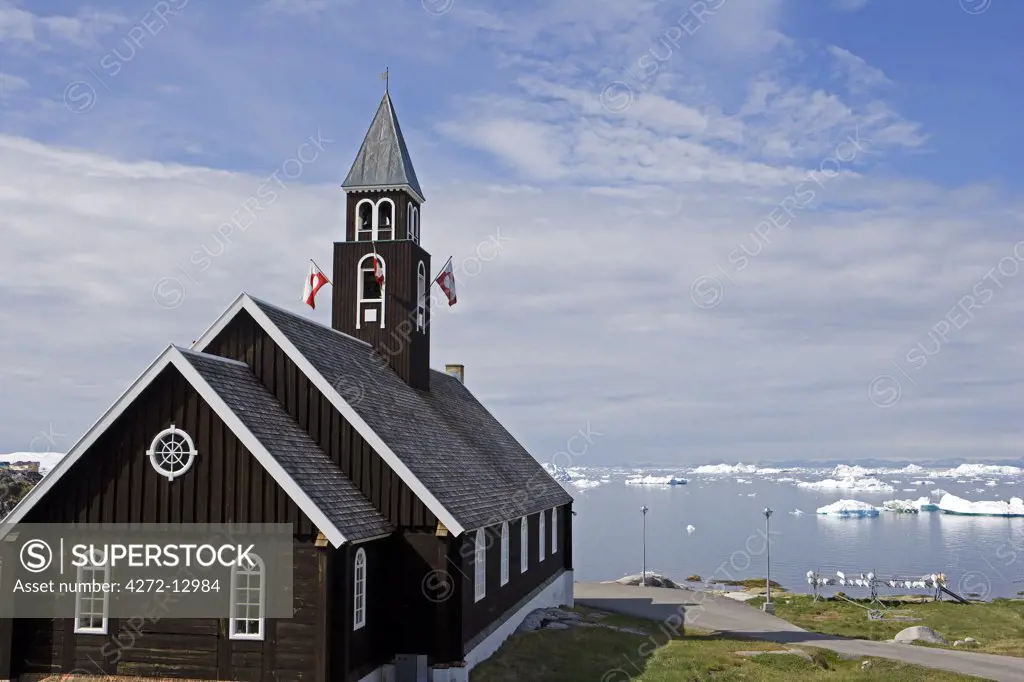 Greenland, Ilulissat, UNESCO World Heritage Site Icefjord.  Traditional wooden built church overlooks the embayment.   The  Zions Church, was built in 1782, and was paid in full by a collection among the locals.