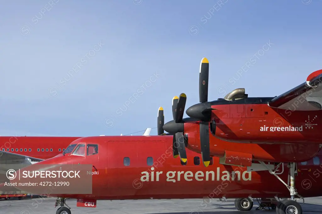 Greenland, Ilulissat, Kangerlussak. A red liveried Air Greenland flight waits on the apron at the former American airbase for passengers.