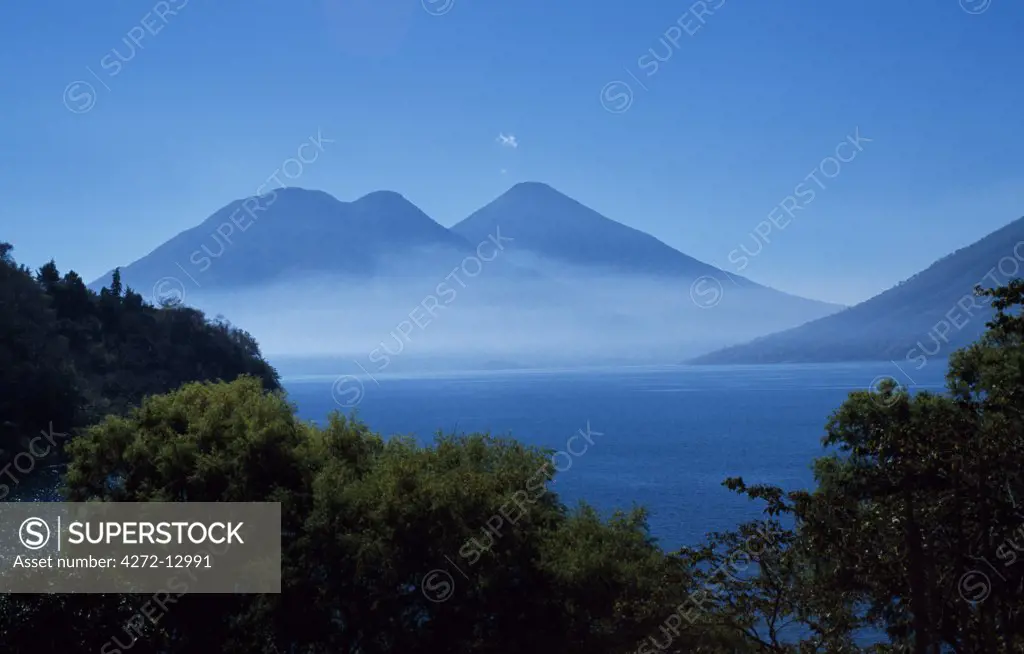Mist hovers in front of volcanoes Toliman and Atitlan.