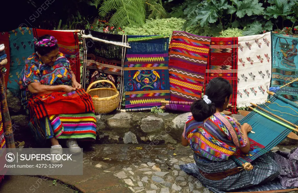 Women sit weaving, a craft weaving which is practised in every town and village in the Western Highlands.
