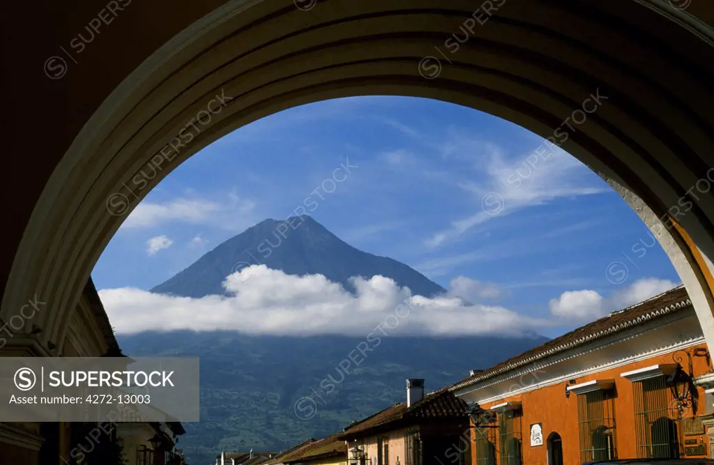 The 3766 metre high Agua Volcano, one of three that dominate the skyline around Antigua, is framed by the arch of Santa Catalina convent.