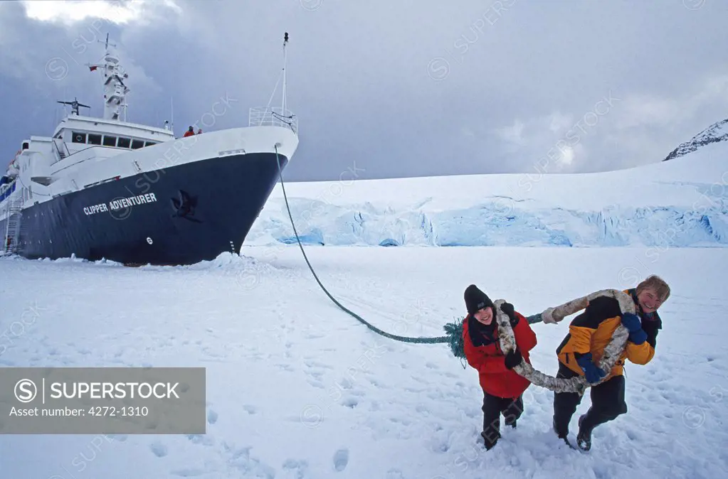Antarctica, Wiencke Island, Port Lockroy. 'Towing the ship' Expedition ship 'Clipper Adventurer' garaged in sea-ice