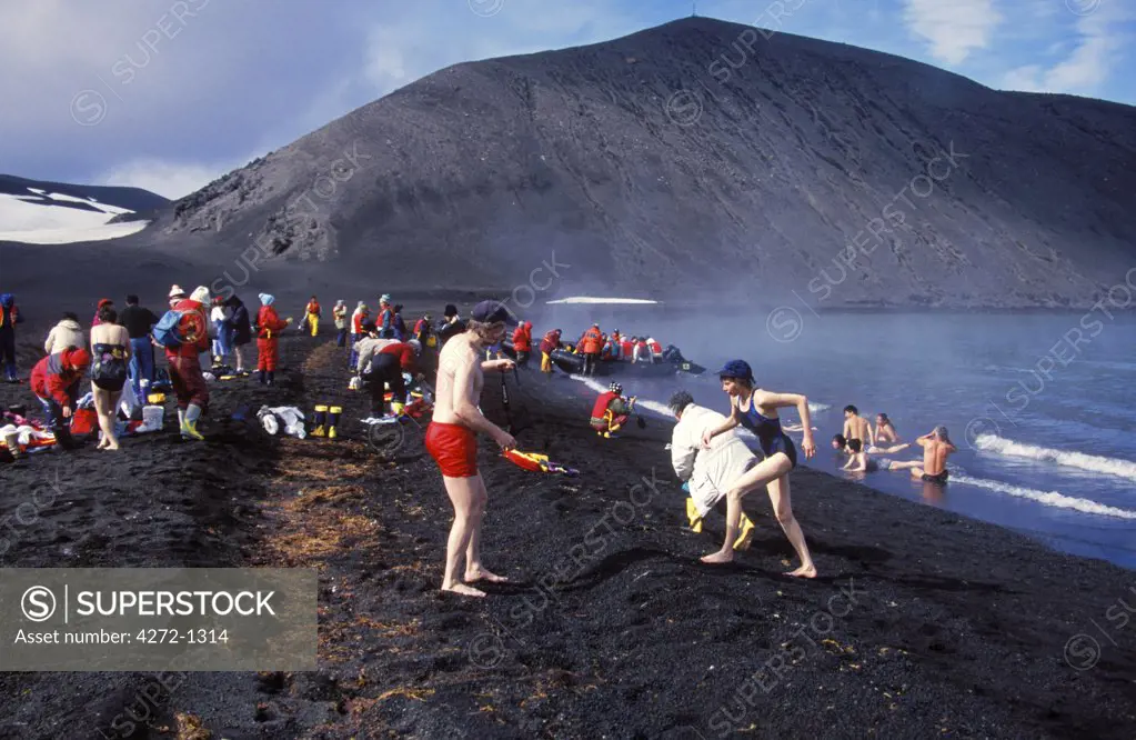 Antarctica, South Shetland Islands, Deception Island. Cruise vessel tourists bathing in volcanically heated water