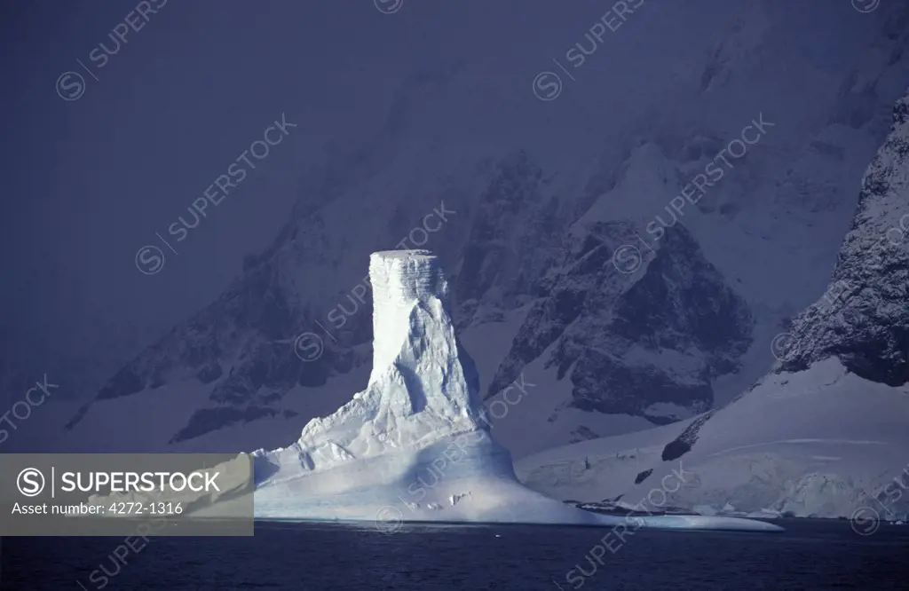 Antarctica, Penola Strait, Pleneau island. Columnar iceberg in evening light