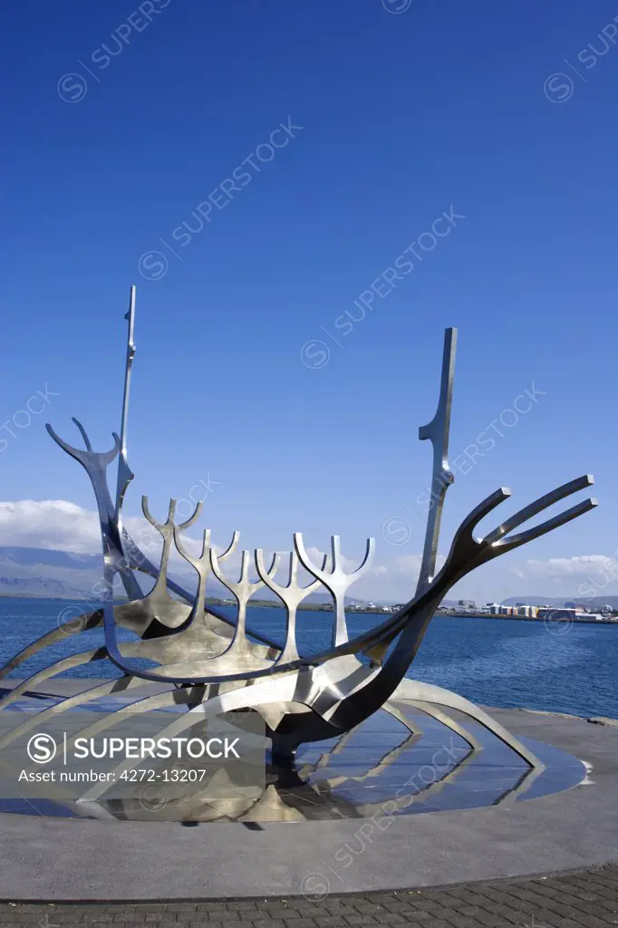 Iceland, Reykjavik. Sulfar (Sun Craft), sculpture close to the old harbour in Reykjavik, it is an abstract representation of a viking ship with the mountains of Akrafjall and Esjan in the background.