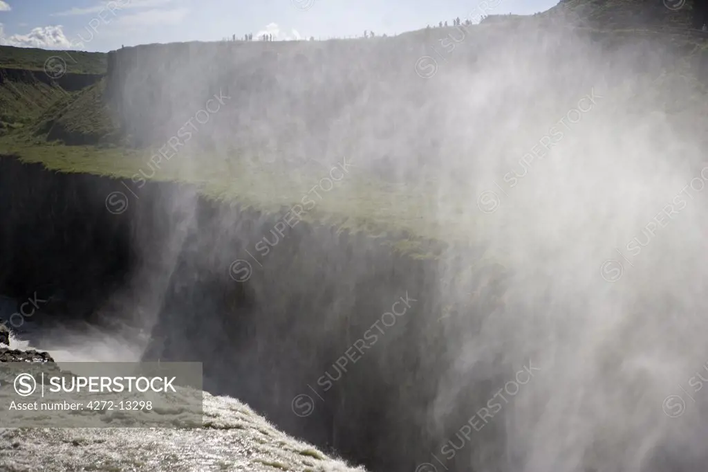 Iceland. Gullfoss (Golden Falls) is a magnificient 32m high double waterfall on the White River (Hv_ta). The flow of the river from the regular rains and the glacial runoff, particularly in summer, makes it the largest volume falls in Europe.