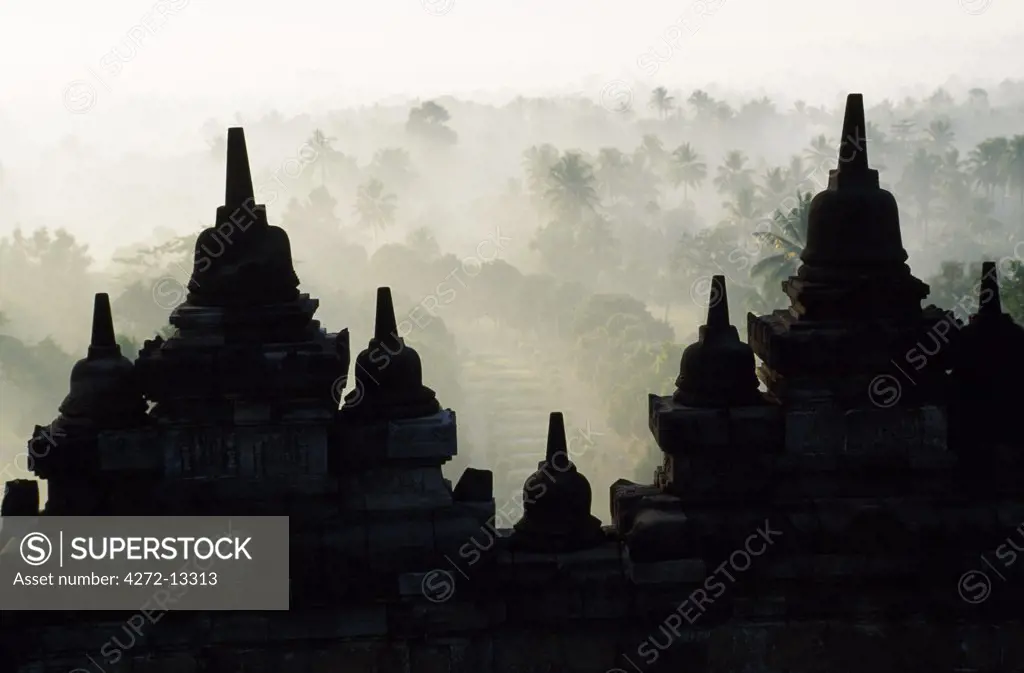 Latticed stupas on upper terraces, Borobodur temple, Java, Indonesia. Ranking with Pagan and Angkor as one of the greatest Southeast Asian monuments, Borobodor is an enormous construction standing majestically on a hill overlooking lush green fields and distant hills, 42km northwest of Yogyakarta.