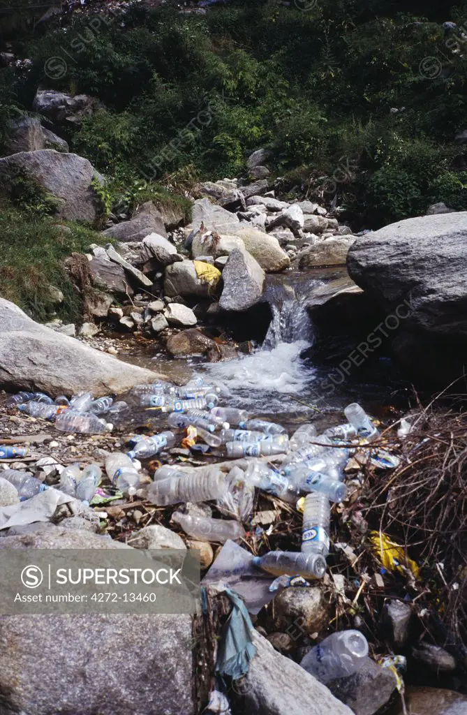 Litter in stream.  Tourism brings consumer disposables to a culture which, until recently, had no concept of waste.