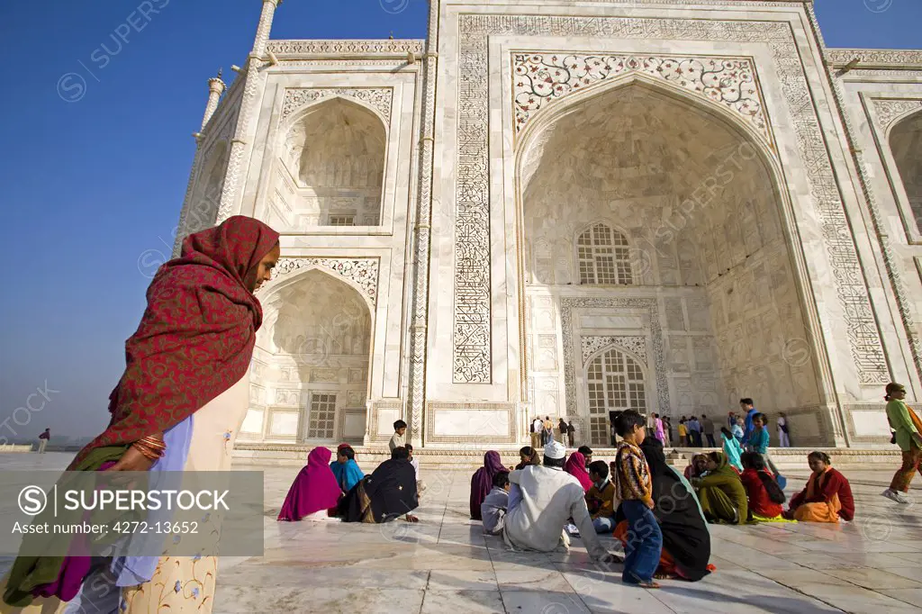 Pligrims and Indian families resting outside of main facade of Taj Mahal, Agra. India.