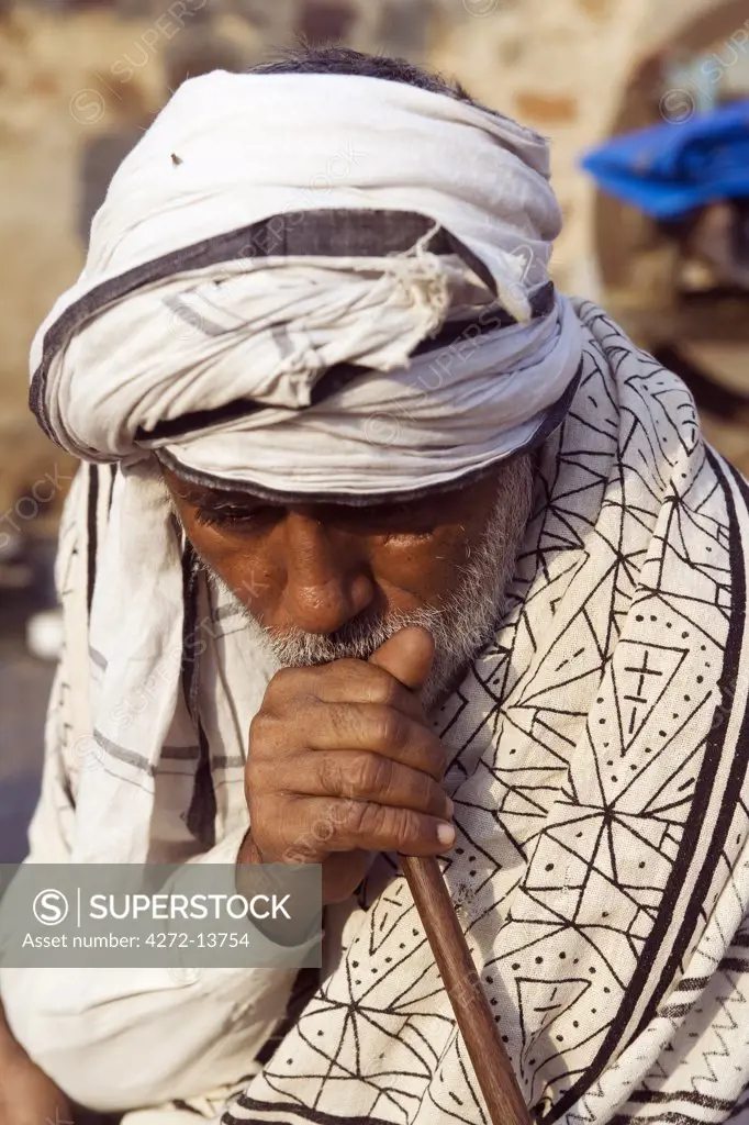 India, Rajasthan, Rohet.  At the end of the day, the family patriarch relaxes with a water pipe smoke in the courtyard of his farm house.