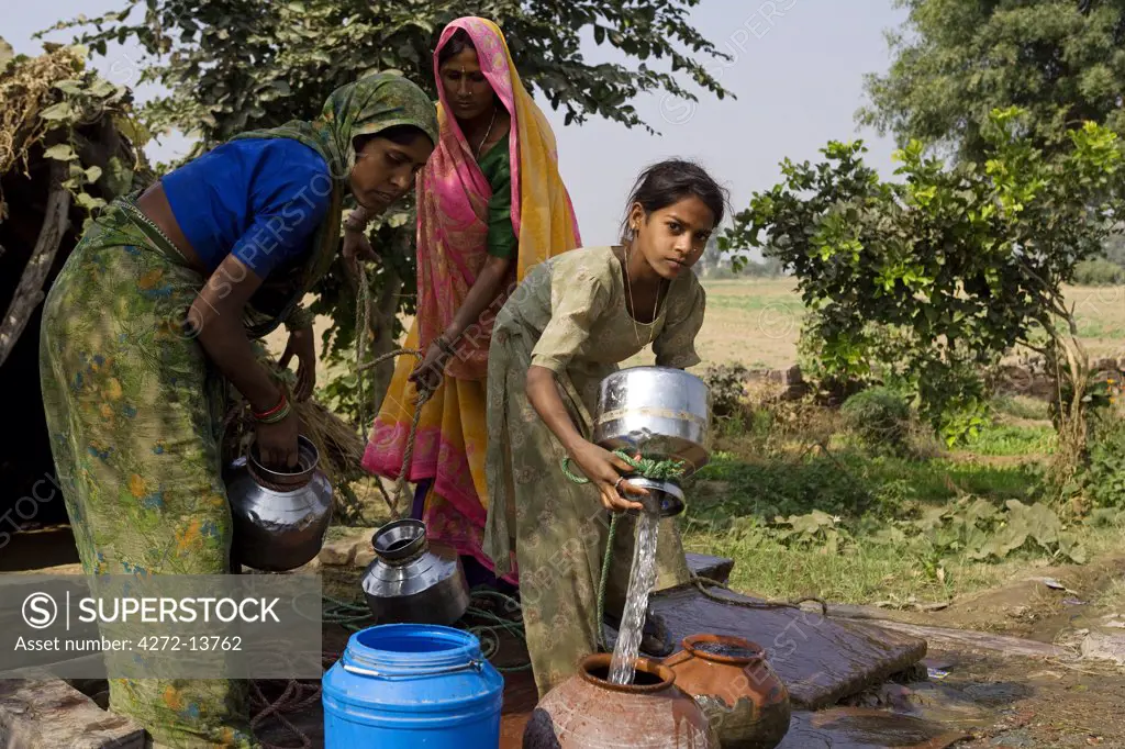 India, Rajasthan, Rohet.  Without running water in their homes, the village well and water pump become a meeting point for the women of the communities.